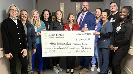 Caregivers from the Marlborough Campus hold a large-size copy of the donation check.