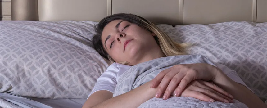 A woman sleeps on her back with help from mindfulness.